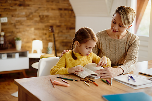 small-girl-reading-book-while-learning-with-help-her-mother-home500px